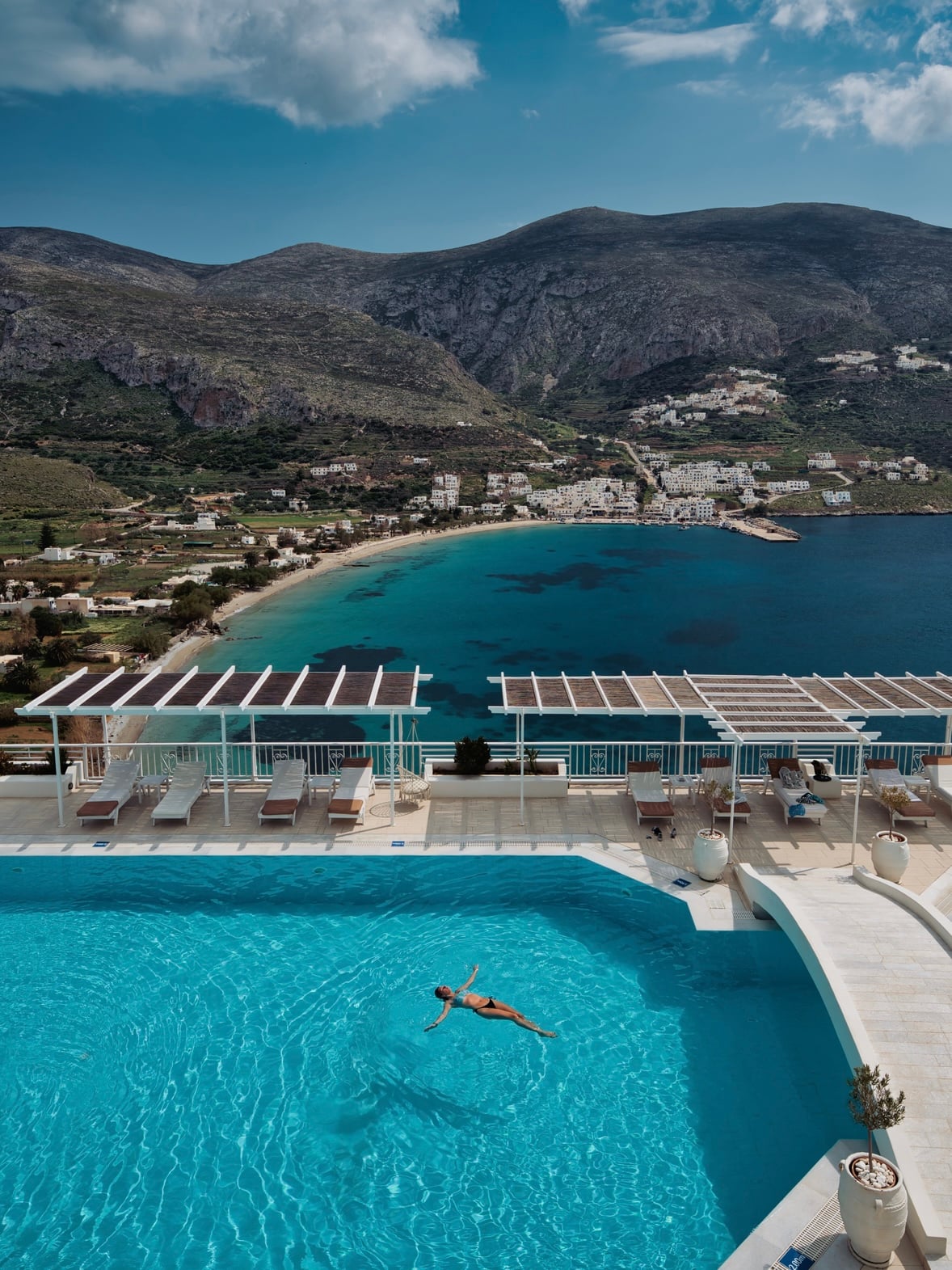 Infinity pool overlooking the Aegean, with a guest swimming