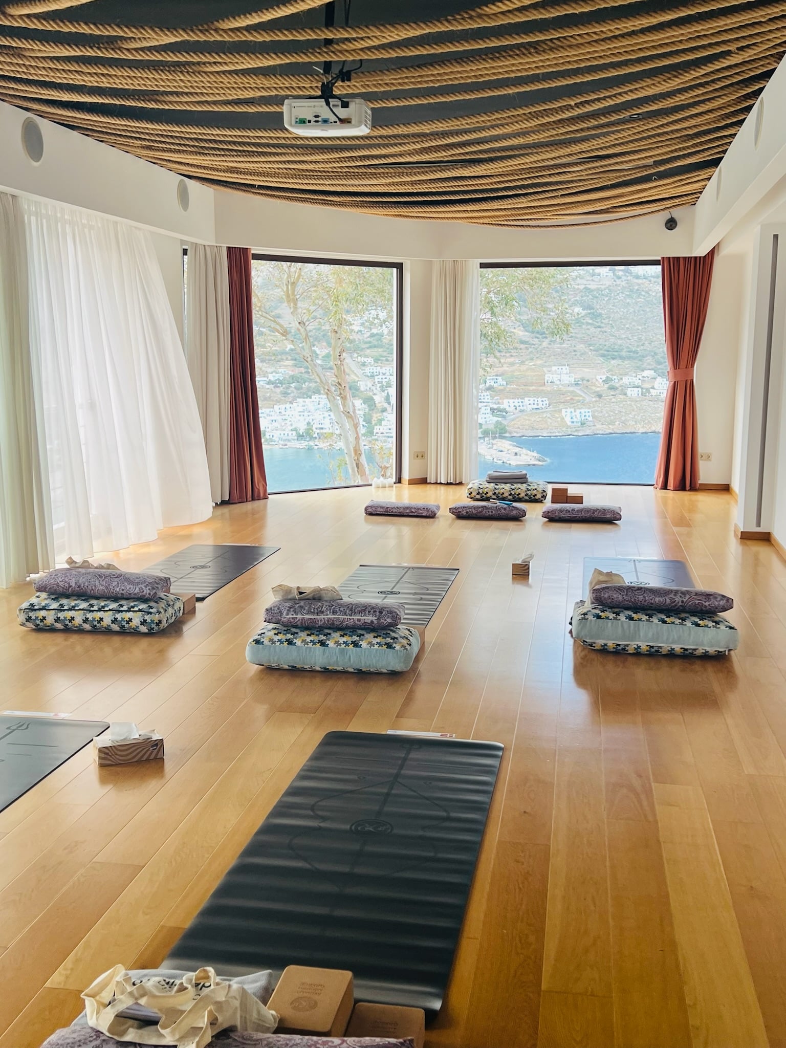 Indoor shala with mats set up, windows over the bay