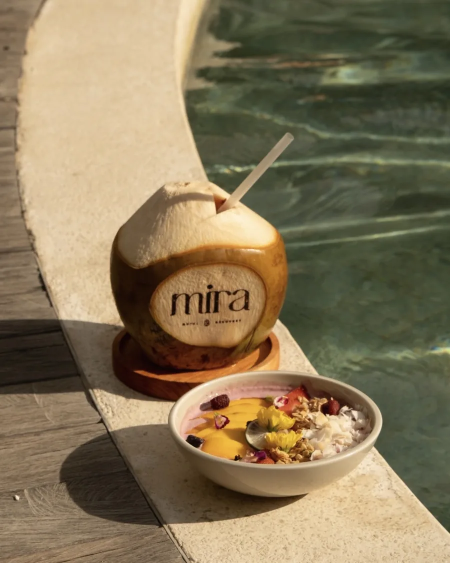A breakfast bowl and fresh coconut at the poolside